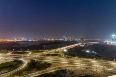 a highway at night with a city in the background at FIRST CLASS 3BR Luxury Meets Tranquility in Dubai