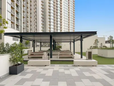 a gazebo with benches in a park with tall buildings at FIRST CLASS 3BR Luxury Meets Tranquility in Dubai
