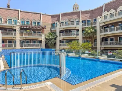 a large swimming pool in front of a building at Chic Studio in JVC near Butterfly and Miracle Garden in Dubai