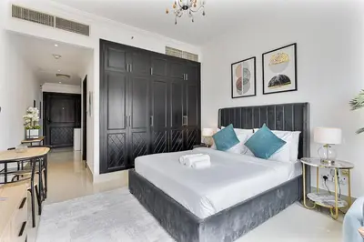 a bedroom with a large bed and a table and chairs at Chic Studio in JVC near Butterfly and Miracle Garden in Dubai