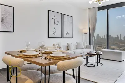 a white living room with a table and chairs at Bookable 2 Bed Crest Sobha Hartland with Burj view in Dubai