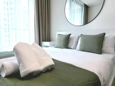 a bedroom with a large white bed with a mirror at Royalton - Modern JVC Studio Escape in Dubai