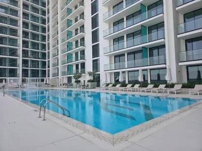 a large swimming pool in front of a building at Royalton - Modern JVC Studio Escape in Dubai