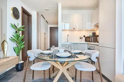 a kitchen and dining room with a table and chairs at STAY BY LATINEM Luxury 1BR Holiday Home CB 3306 Near Burj Khalifa in Dubai