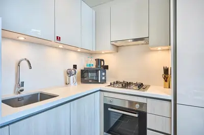 a kitchen with white cabinets and a sink and a stove at STAY BY LATINEM Luxury 1BR Holiday Home CB 3306 Near Burj Khalifa in Dubai