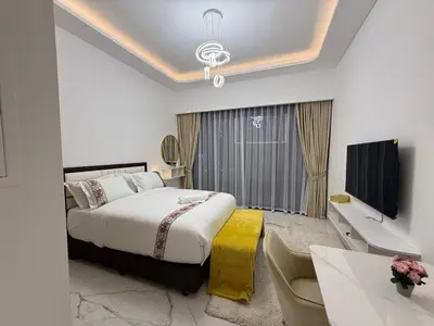 a bedroom with a bed and a tv and a couch at Azizi 205 Fully Furnished Apartment in Dubai