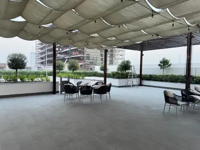 a large patio with chairs and a table on a building at Azizi 205 Fully Furnished Apartment in Dubai