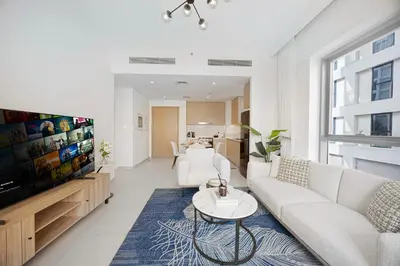 a living room with white furniture and a flat screen tv at Daniels 1BR at Bayshore 4 Creek Beach in Dubai