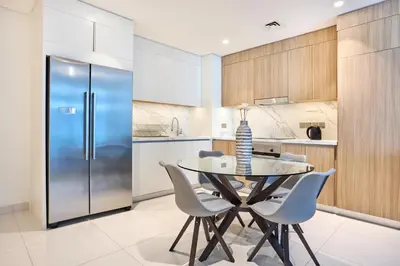 a kitchen with a table and chairs and a refrigerator at Beach Vista - Stunning Sea View in Dubai