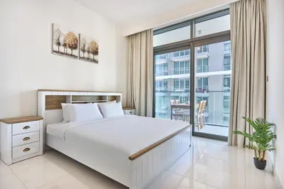 a bedroom with a white bed and a large window at Beach Vista - Stunning Sea View in Dubai