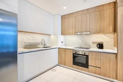 a kitchen with white counters and wooden cabinets at Beach Vista - Stunning Sea View in Dubai