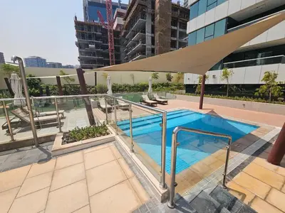 a swimming pool with an umbrella on top of a building at Chic Studio close to Dubai Mall with Canal Views in Dubai