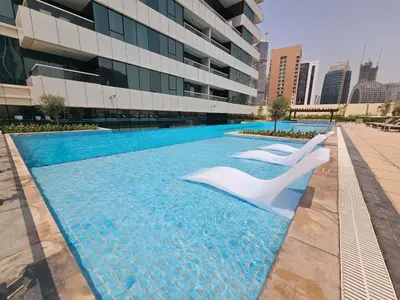 a swimming pool in front of a building at Chic Studio close to Dubai Mall with Canal Views in Dubai