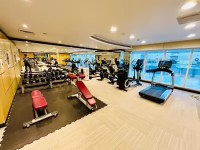 a gym with treadmills and machines in a building at Chic Studio close to Dubai Mall with Canal Views in Dubai