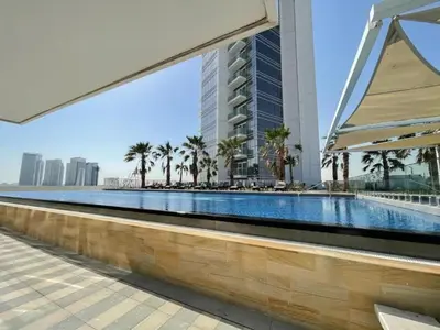 a swimming pool in a building with palm trees at Vacationer I Luxury Studio I Scenic Golf Course & Skyline Views I Carson B Tower in Dubai Marina