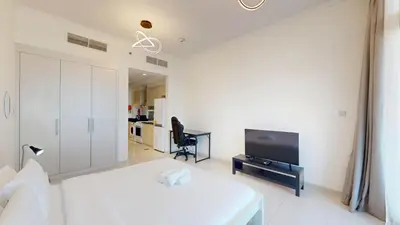 a living room with a bed and a tv at Vacationer I Luxury Studio I Scenic Golf Course & Skyline Views I Carson B Tower in Dubai Marina
