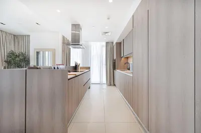 a kitchen with wooden cabinets and a long hallway at Luxury 3 Bedroom Apartment in Bluewaters Residences in Dubai