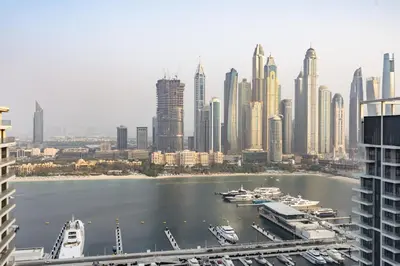 a view of a large city with boats in the water at Elegant 2BR with Sea View & Direct Beach Access in Dubai