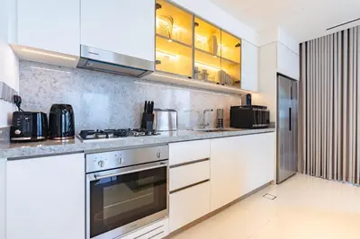 a kitchen with white cabinets and a stove at Elegant 2BR with Sea View & Direct Beach Access in Dubai