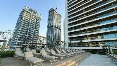 a row of chairs sitting in front of tall buildings at Elegant 2BR with Sea View & Direct Beach Access in Dubai