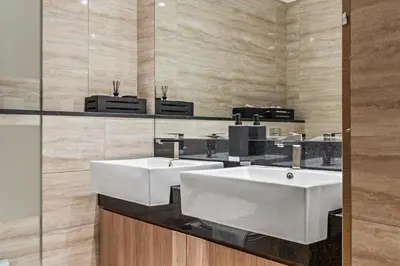 a bathroom with two white sinks and a mirror at Millionaire Residence-Infinity Pool-Business Bay in Dubai