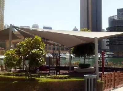 a white umbrella in a park with a playground at 70m2 Bay Central-Luxury One Bedroom with Spectacular Marina Views in Dubai