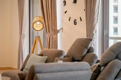 a living room with a couch and a clock on the wall at HiGuests - Fancy 1BR Apt With Aerial Marina Views in JBR in Dubai