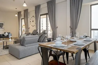 a living room with a wooden table and chairs at HiGuests - Fancy 1BR Apt With Aerial Marina Views in JBR in Dubai
