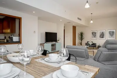 a living room with a table with wine glasses at HiGuests - Fancy 1BR Apt With Aerial Marina Views in JBR in Dubai