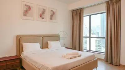 a bedroom with a bed and a large window at Premium 1BR With Stunning Marina & Sea Views in Dubai