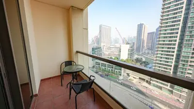 a balcony with two chairs and a view of a city at Premium 1BR With Stunning Marina & Sea Views in Dubai