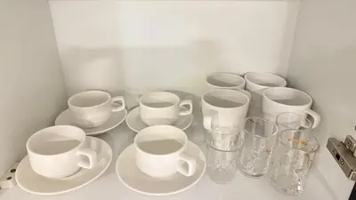 a group of cups and plates and glasses on a counter at DAMAC - Bays Edge 1BR - Burj Khalifa Views & Pool in Dubai