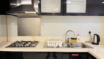 a kitchen counter with a sink and a stove at DAMAC - Bays Edge 1BR - Burj Khalifa Views & Pool in Dubai