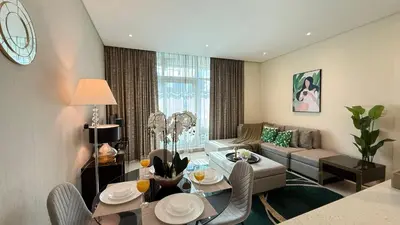 a living room with a couch and a table and chairs at DAMAC - Bays Edge 1BR - Burj Khalifa Views & Pool in Dubai