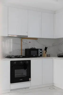 a kitchen with a black oven and a microwave at Brand New Grand 2BR Duplex apartment in Jumeirah Village Circle with Pool, Gym and kids playground in Dubai