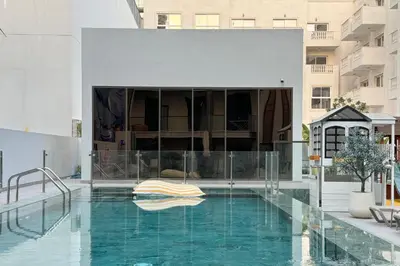 a swimming pool in the middle of a building at Brand New Grand 2BR Duplex apartment in Jumeirah Village Circle with Pool, Gym and kids playground in Dubai