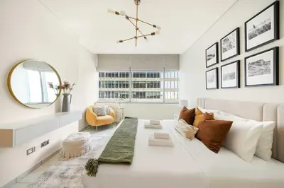 a white living room with a large white couch at Silkhaus Luxurious 1BR at Sky Gardens in DIFC in Dubai