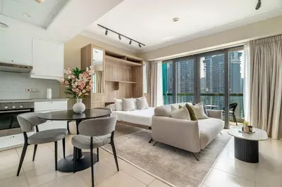 a living room with a bed and a table and chairs at Stylish Living at 8 Boulevard Walk, Downtown in Dubai