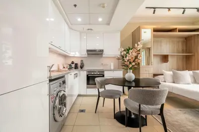 a kitchen and living room with a table and chairs at Stylish Living at 8 Boulevard Walk, Downtown in Dubai