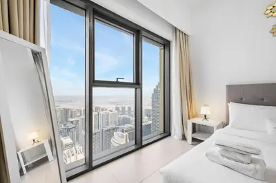 a bedroom with a bed and large windows at Downtown Comfort Spacious 1BR in Burj Royale in Dubai