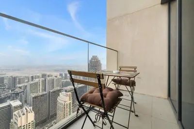 a balcony with a table and chairs on top of a building at Downtown Comfort Spacious 1BR in Burj Royale in Dubai