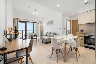 a kitchen and living room with a table and chairs at Downtown Comfort Spacious 1BR in Burj Royale in Dubai
