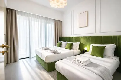 a hotel room with two beds with green accents at 1BR in Emaar Burj Royale - 1min walk to Fountain&Dubai Mall, Burj view Pool & gym in Dubai