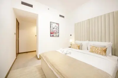 a bedroom with a large white bed in a room at Spacious 2BR in Missoni - Canal Views - Near Metro in Dubai