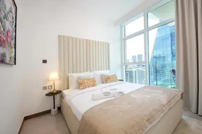 a bedroom with a large bed with a large window at Spacious 2BR in Missoni - Canal Views - Near Metro in Dubai