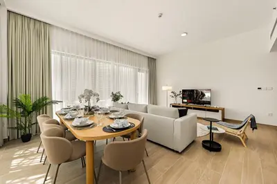 a living room with a table and a couch at New 3BD in Grove Creek Beach with Stunning View in Dubai
