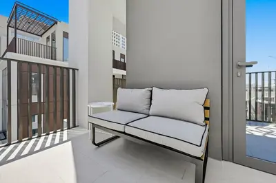 a couch on the balcony of a building at New 3BD in Grove Creek Beach with Stunning View in Dubai