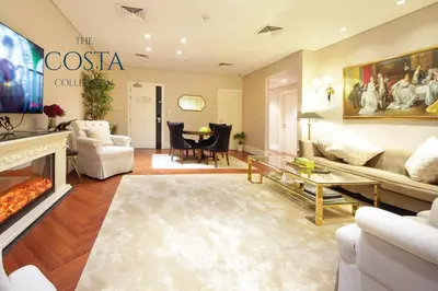a living room with a couch and a fireplace at Water Edge 2BR - Panoramic 360 Canal View in Dubai