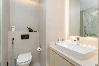 a white bathroom with a sink and a toilet at 1BR w Marina Views & Balcony in Dubai