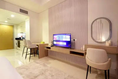 a living room with a television and a table with chairs at Luxury Studio in Aykon Tower - Pool & Gym Access in Dubai
